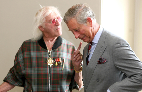 Savile takes Princess Diana's hand as the Queen Mother looks on